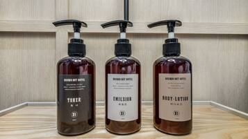 Three bottles of Brown Dot Hotel products: toner, emulsion, and body lotion.