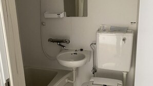 A small, compact bathroom with a toilet, sink, and shower. - Hotel46 (Hashimoto)