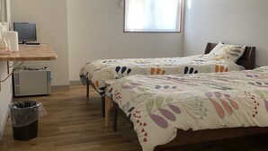 A bedroom with two beds, a desk with a computer, and a window with curtains. - Hotel46 (Hashimoto)