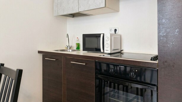 Una cocina equipada con microondas, tostadora, lavaplatos y lavamanos.