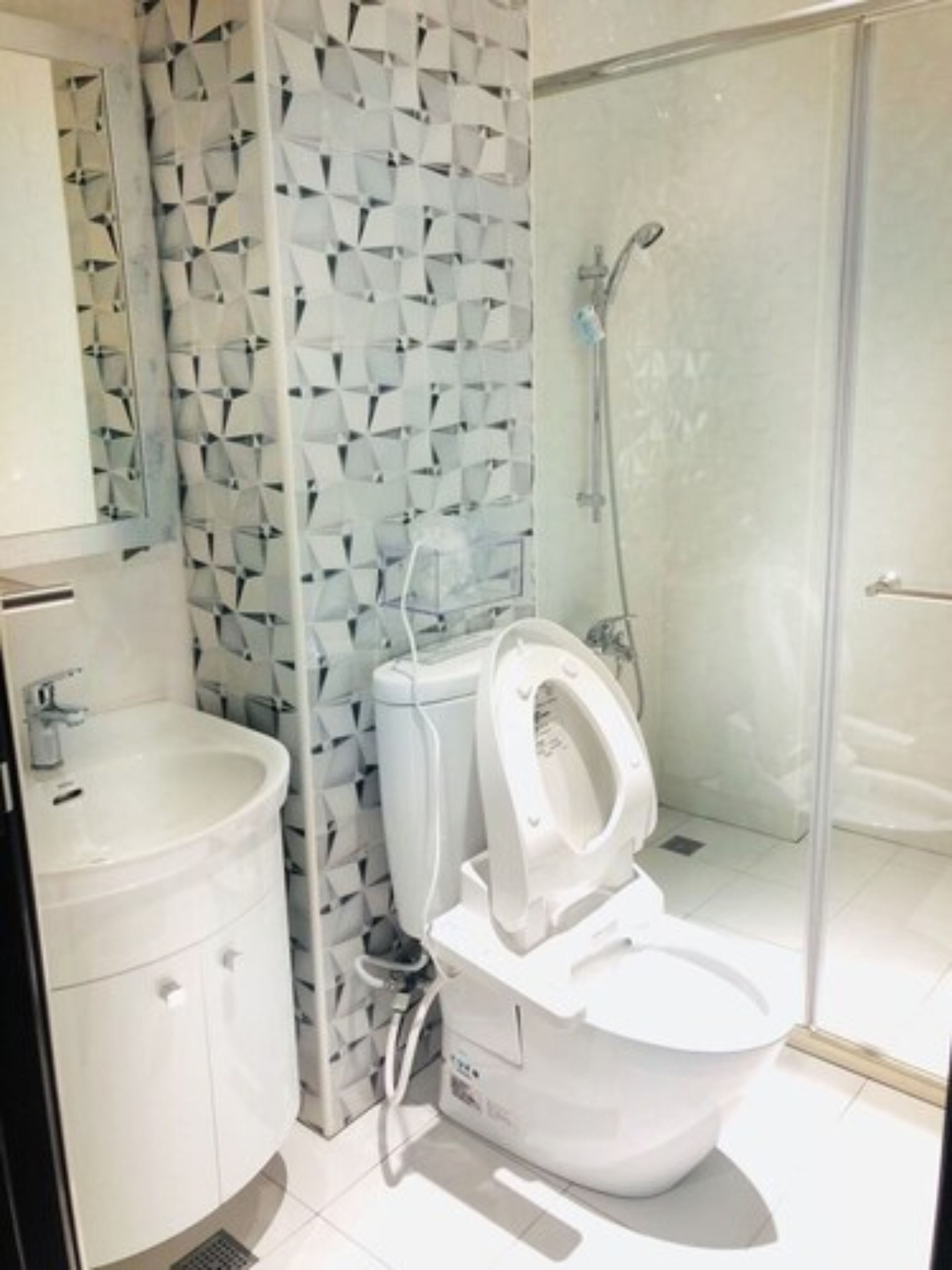 A modern bathroom with a toilet, sink, and shower.