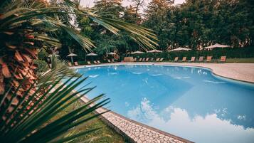 Een buitenzwembad, parasols voor strand/zwembad