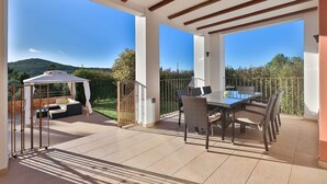 A covered outdoor patio with a dining table and chairs, a gazebo, and a view of a mountainous landscape. - CASA FENIX (Sant Josep de Sa Talaia / San Jose)