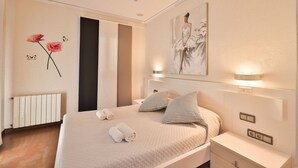 A modern bedroom with a large bed, two bedside tables, a radiator, and wall art. - CASA FENIX (Sant Josep de Sa Talaia / San Jose)