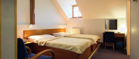 A room with two beds, a desk, and a chair.