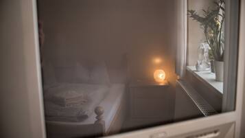 Ein Schlafzimmer mit einem Bett, einem Nachttisch und einem Beistelltisch mit einer Lampe.