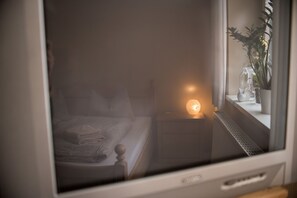 Ein Schlafzimmer mit einem Bett, einem Nachttisch und einem Beistelltisch mit einer Lampe.