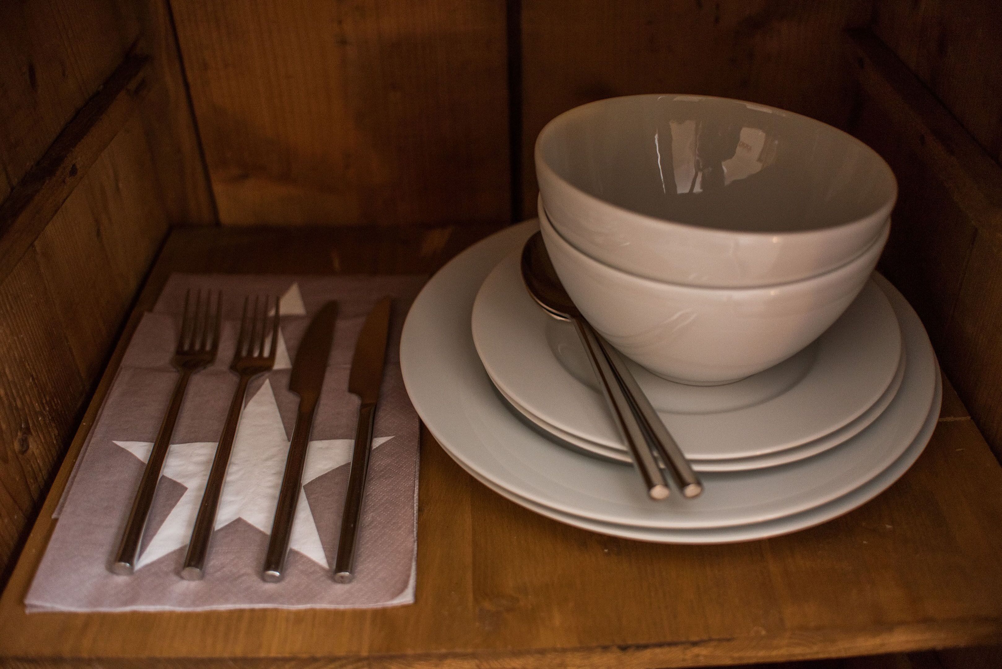 Un ensemble de couverts et d’assiettes disposés sur une table en bois.