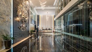 A modern lobby with a polished marble floor, a reception desk, and contemporary lighting fixtures. - Swiss-Belhotel Darmo Surabaya (Surabaya)