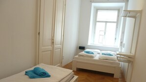 A small, clean room with a bed, a bench, and a window. - Extremely central 2 BR Apartment next to St  Stephen Cathedral (Vienna)