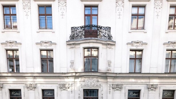 A historic building with ornate architectural details, including a central entrance with a decorative arch and statues, and multiple windows with the name "Rahimi" displayed. - Extremely central 2 BR Apartment next to St  Stephen Cathedral (Vienna)