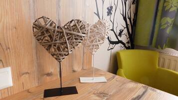 A wooden table with two heart-shaped sculptures and a black stand.