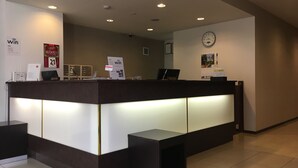 A reception desk with a digital clock, a sign indicating WiFi availability, and a clock on the wall. - Hotel Aisis Kakegawa (Kakegawa)