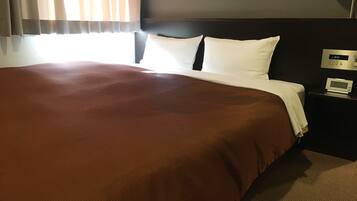 Quarto de hotel com uma cama grande, mesa de cabeceira com relógio e janela com cortinas.