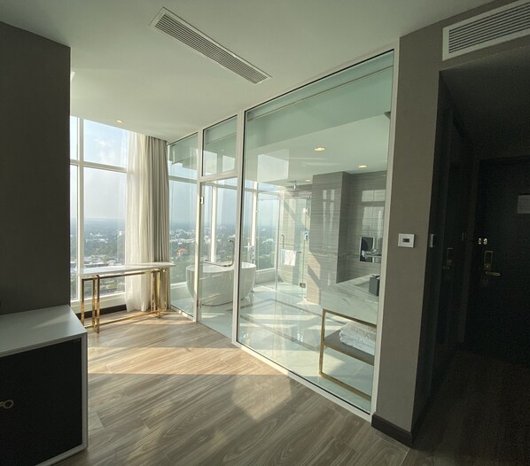 A modern hotel room with a large sliding glass door leading to a balcony, a wooden floor, and a minimalist design. - Diamond Stars Ben Tre Hotel (Ben Tre)