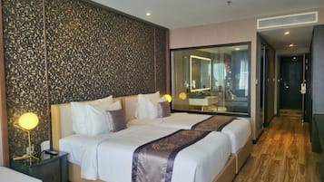 Habitación de hotel con una cama grande, una mesita de noche, un espejo y vistas al baño.