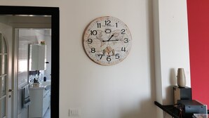 Een keuken met witte kasten, een witte koelkast en een raam.
