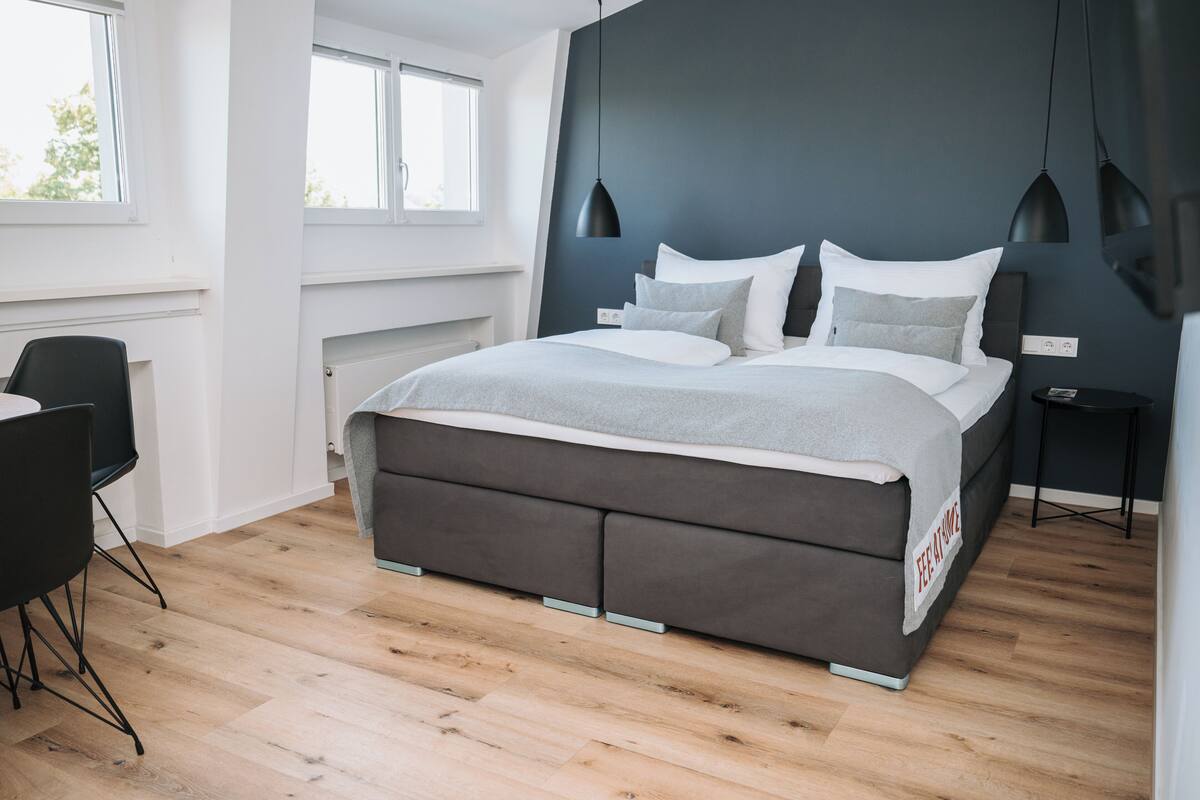 Un dormitorio moderno con una cama grande, un escritorio y una silla.