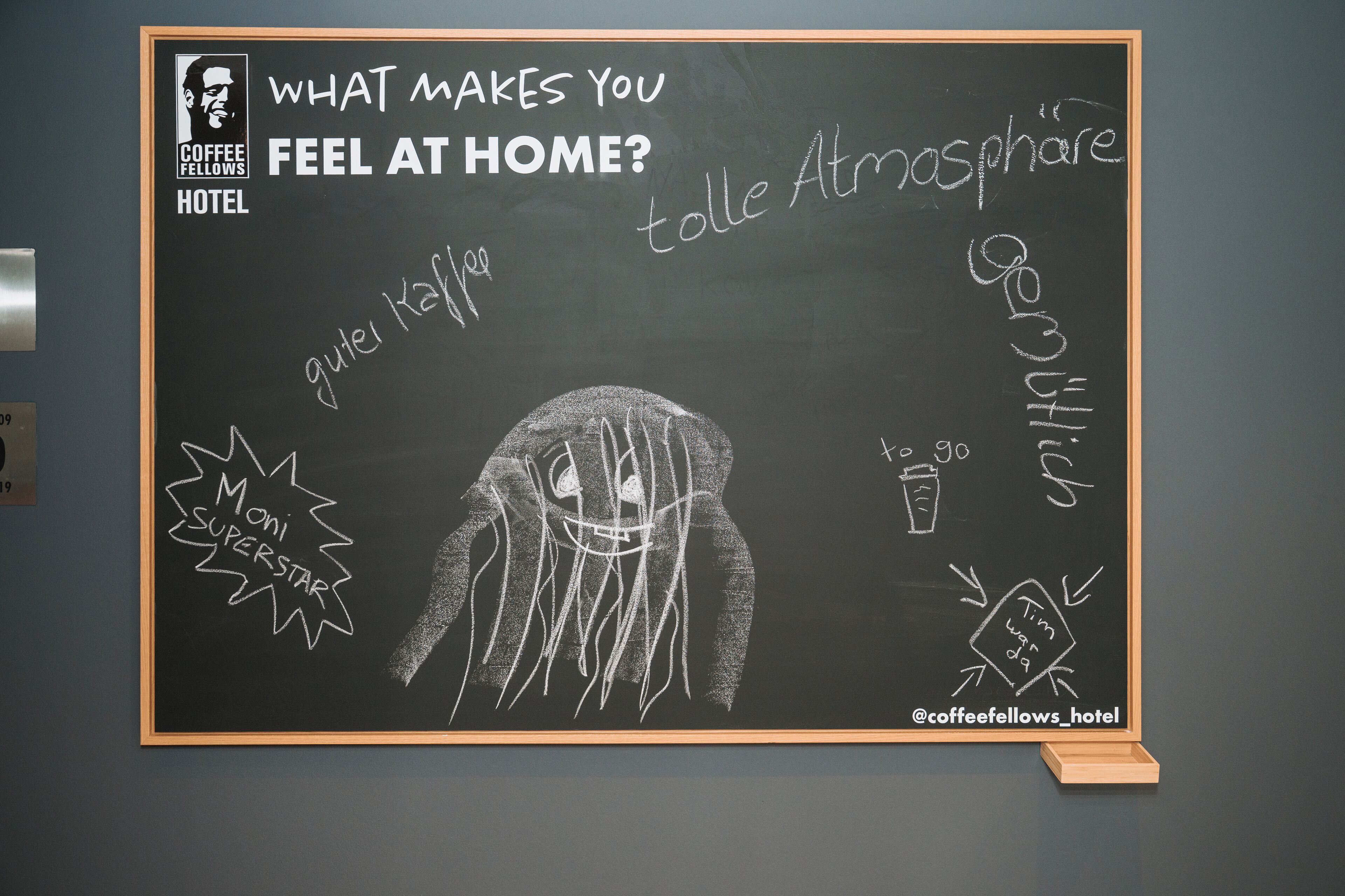 A blackboard with a drawing of a person and text related to a hotel.