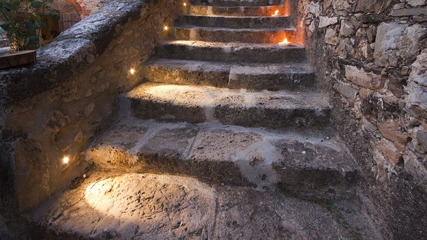 A stone staircase in a narrow alleyway with a rustic building on one side and a wall on the other. - Agriturismo La Via dell'Oliviera (Chiusdino)