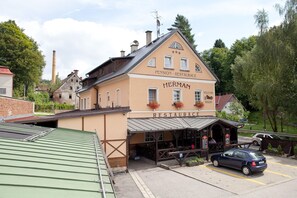 En traditionell tysk restaurang av typen "Pension", med ett skylt, uteservering och en parkeringsplats.