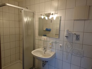 Chuveiro, secador de cabelo, toalhas de banho, sabonete