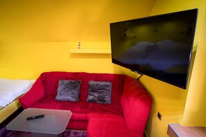 Relax in comfort with a sofa, flat-screen TV, and convenient table.