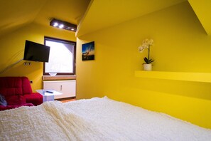 Relax in this cozy retreat with a plush bed, a comfortable sofa, and a flat-screen TV mounted on the ceiling.