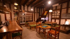A traditional Japanese izakaya with wooden furniture, a bar area, and a cozy seating arrangement.