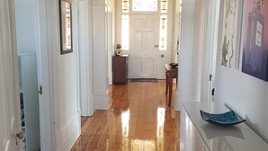 A hallway with wooden flooring, white walls, and a white door at the end. - Semaphore Sea Breeze-Family Beach/Pool Holiday. 450m to Beach. 20 min to airport (Semaphore)