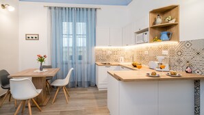 A compact kitchen with a wooden island, white cabinets, and a patterned backsplash. - Old city top spot apartments just one step from the main street Stradun (Dubrovnik)
