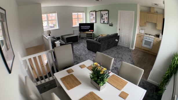 A modern living room with a dining area, a kitchen, and a staircase. - The coach house views netflix sleeps 5 (Leicester)
