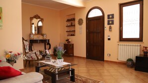 Una sala de estar con sofá, mesa de centro, chimenea y puerta con ventanal.