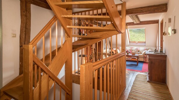 A wooden staircase leading to a loft bedroom with a view of the outdoors. - Apartment 'Achraintal 1' with Mountain View and Wi-Fi (Lindau)