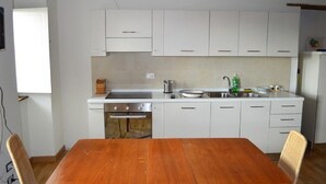 A kitchen with white cabinets, a wooden table, and a built-in oven.