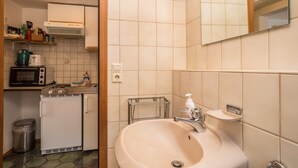 A compact kitchen with a microwave, toaster, and small refrigerator.