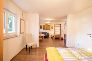 Ein Schlafzimmer mit einem Bett, einem Sessel, einem Schreibtisch und einem Kleiderschrank.