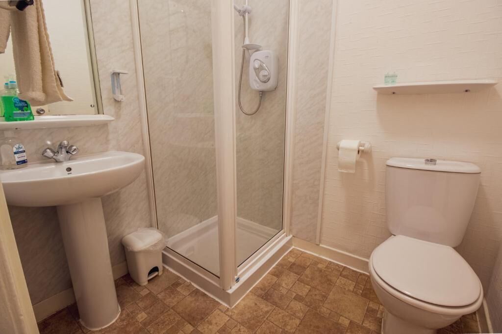 A bathroom with a shower, sink, and toilet.