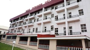 A multi-story hotel with balconies and a red roof.