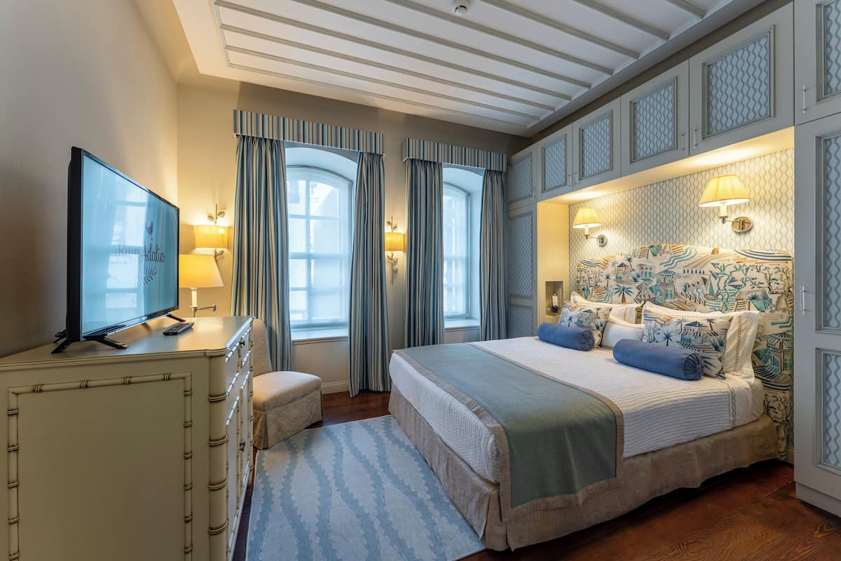 Une chambre d’hôtel avec un lit, une télévision, un bureau et une lampe.