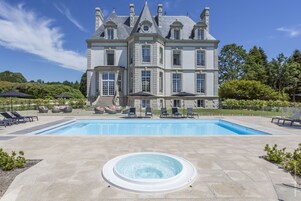Un grand bâtiment élégant, doté d’une piscine et d’un jacuzzi à l’avant.