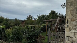 Un edificio de piedra con una escalera de madera que conduce a una terraza de madera.