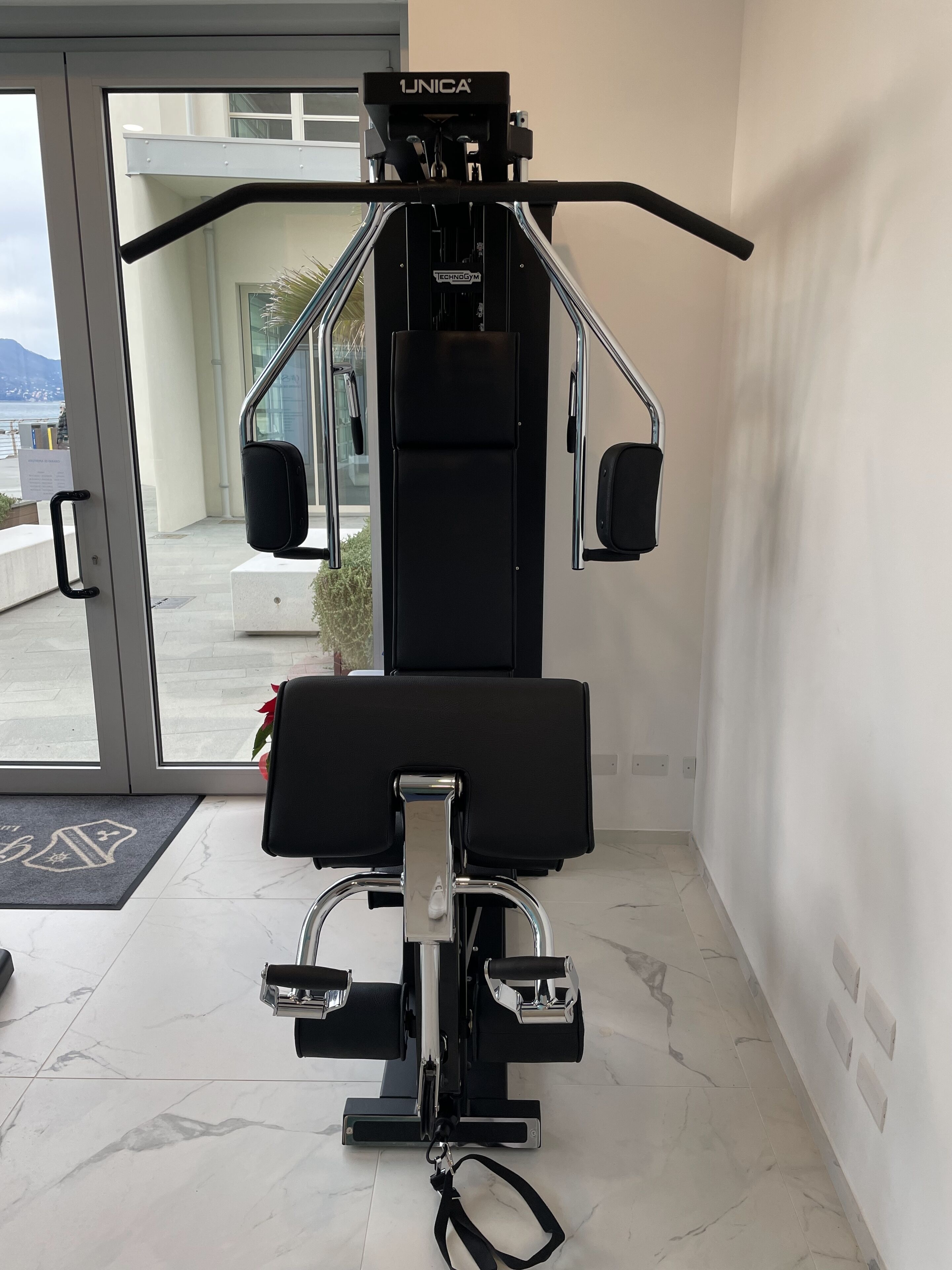 A gym with a pull-up bar, a bench press, and a cable machine.