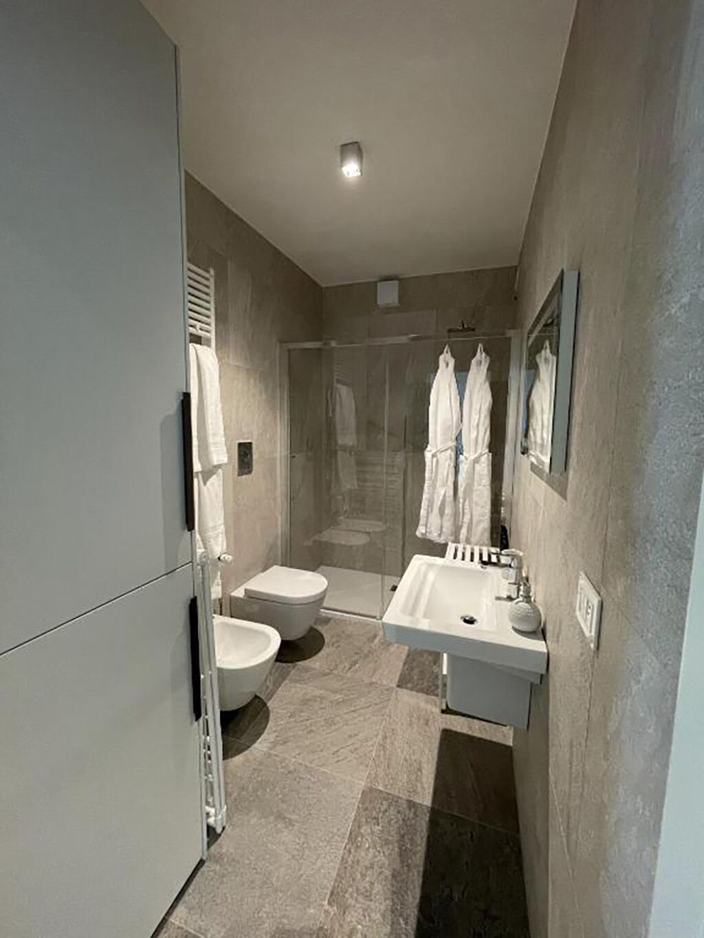 Un baño moderno con ducha, inodoro, bidé y lavamanos.