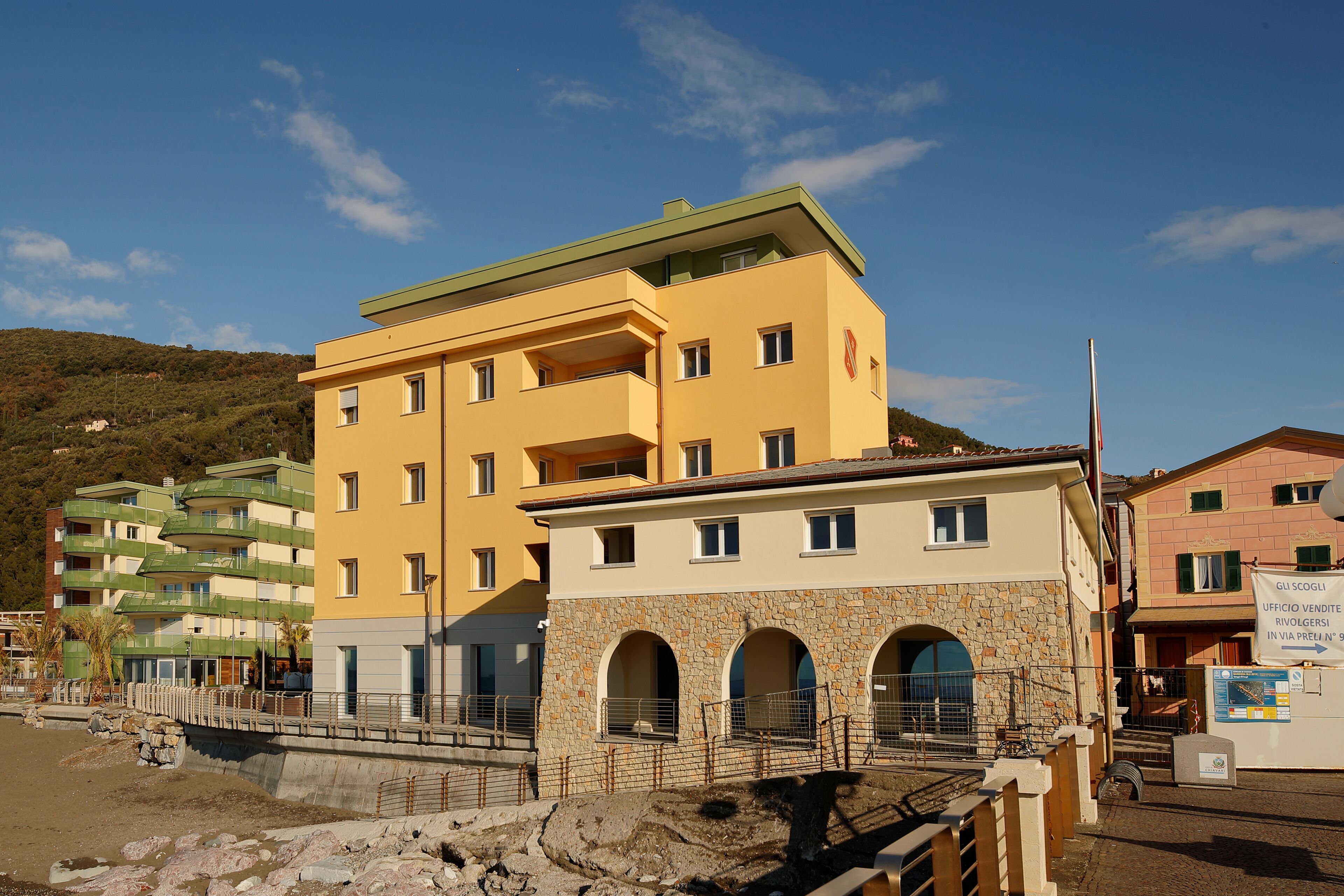 A multi-story hotel with balconies, a stone facade, and a sign indicating it is a commercial property.