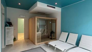 Un spa moderno con techo azul, sillones blancos, entrada por puerta de cristal y una pequeña cabaña de madera.
