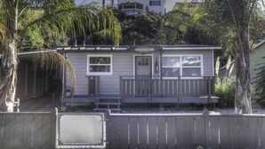 A single-story house with a front porch, a small deck, and a garage.