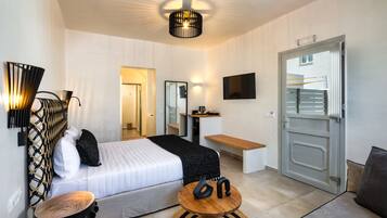 Ein modernes Hotelzimmer mit einem Bett, Nachttisch und einem an der Wand befestigten Fernseher.