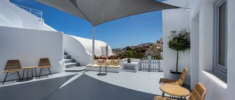 Terraza en la azotea con mobiliario exterior, una estructura grande para dar sombra y vistas a la ciudad.