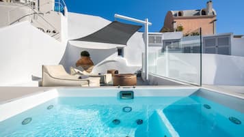 A rooftop pool with a clear blue pool, a covered seating area, and a staircase leading to an upper level.